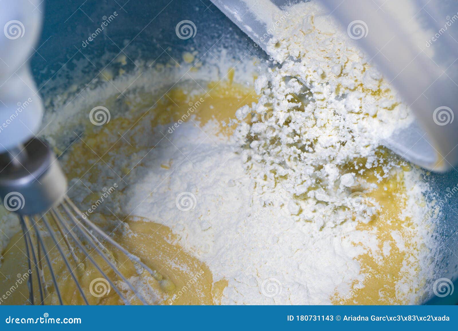 flour falling onto beaten egg to make a dessert.