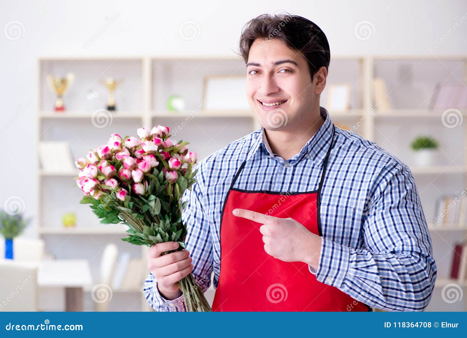 The flower shop assistant offering a bunch of flowers