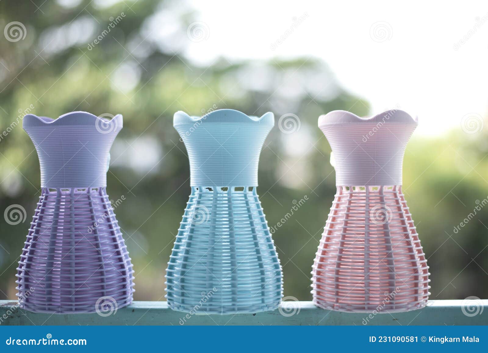 The Flower Vase Made of Plastic on a Green Blur Background of Trees