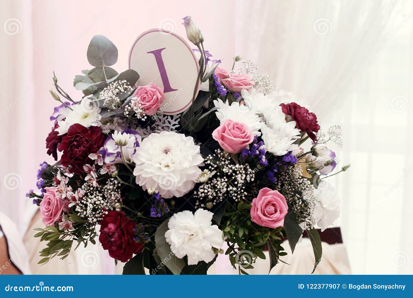 Flowers In Vases And Numbers Of Setting At Wedding Tables With F