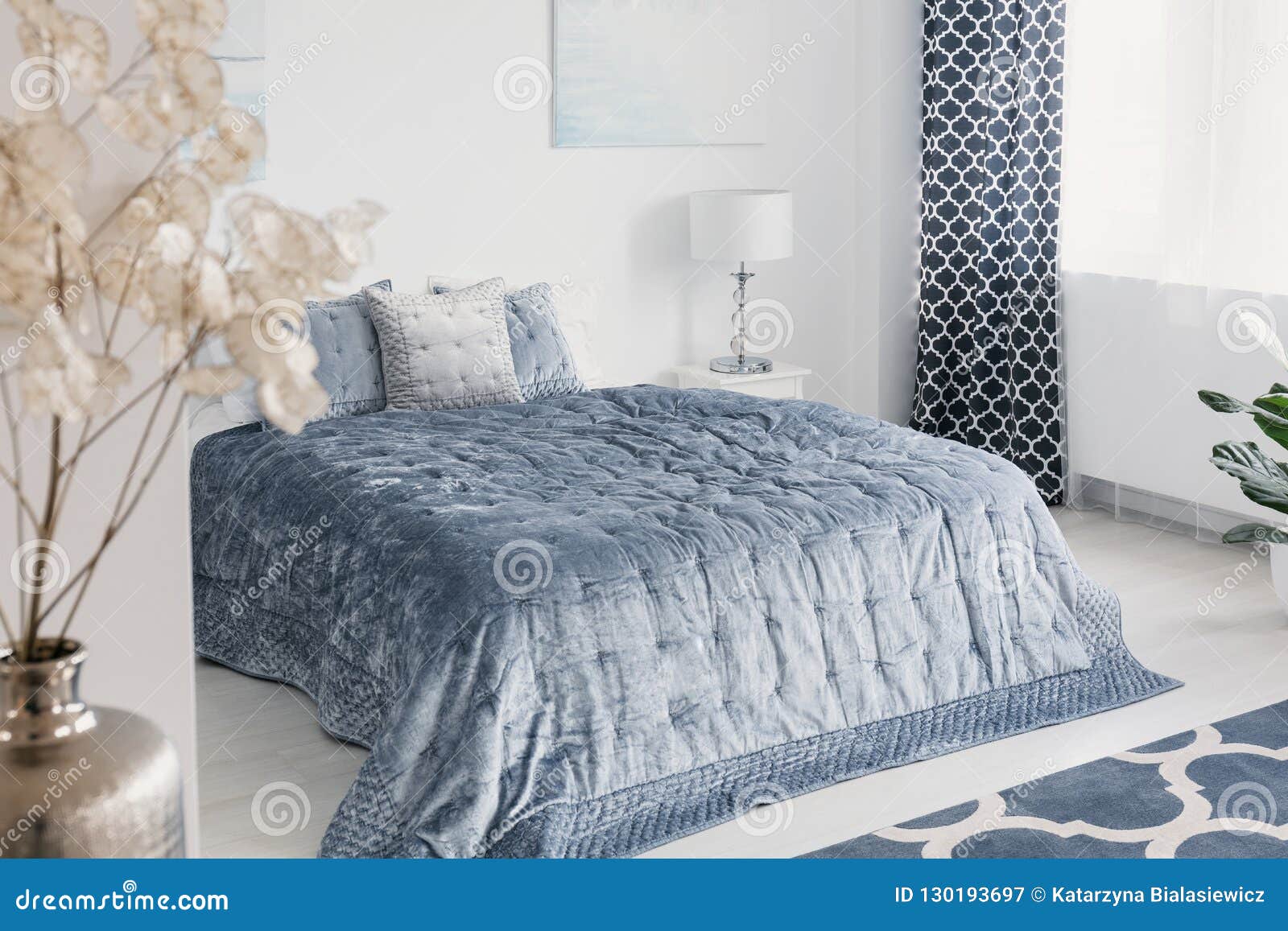 Flowers In White Elegant Bedroom Interior With Blue Sheets On Bed