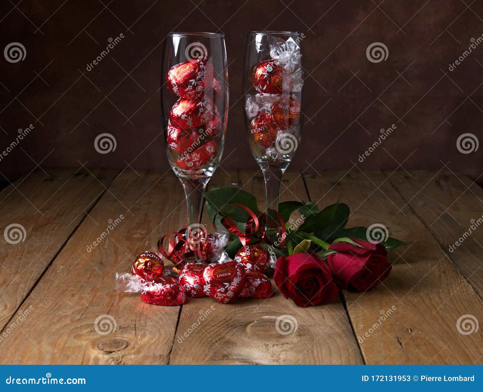 Flute Drinking Glasses Filled with Lindt Chocolates and Red Roses on Brown  Wooden Table with Motled Brown Backdrop Editorial Stock Photo - Image of  delicious, backdrop: 172131953