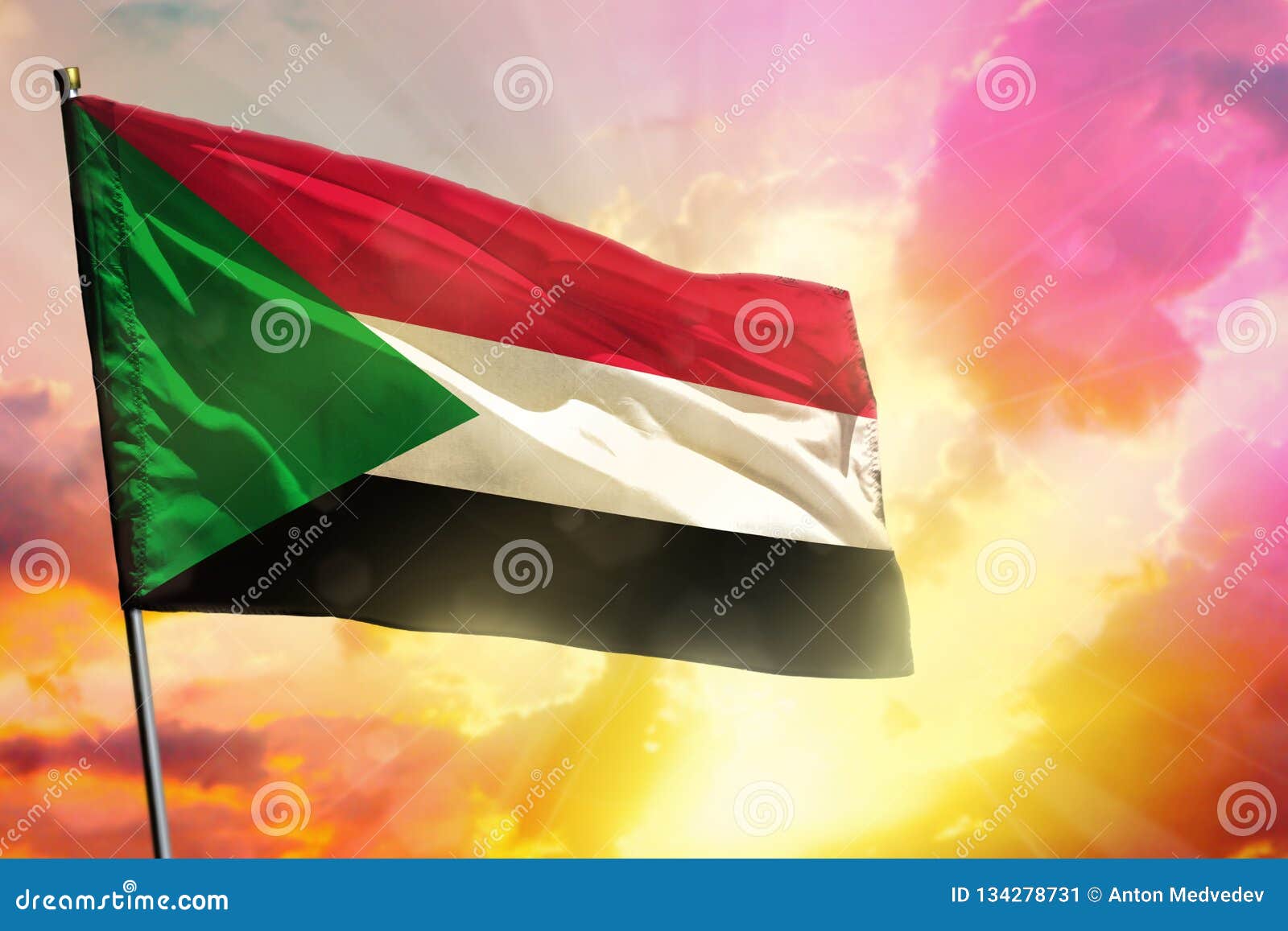 fluttering sudan flag on beautiful colorful sunset or sunrise background. success concept
