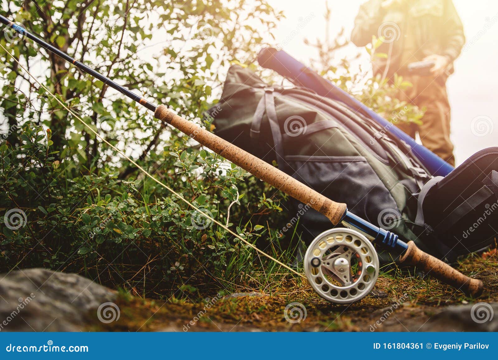 Fly Fishing Rod, Hiking Backpack, in Background Man Dresses