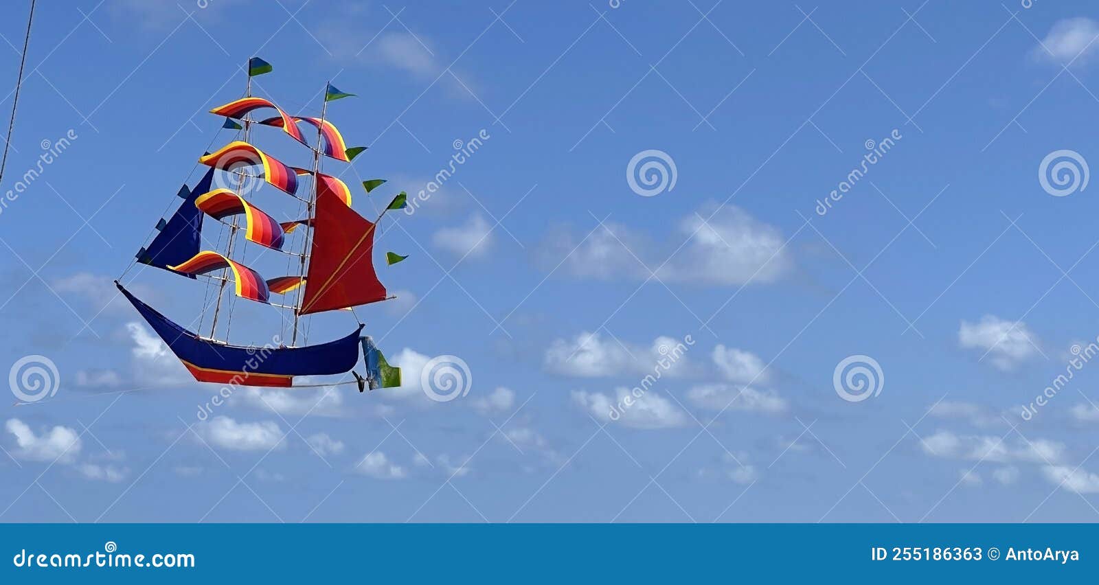 Flying Ship, Rainbow Colored Ship Kite Flies on the Blue Sky and Cloud