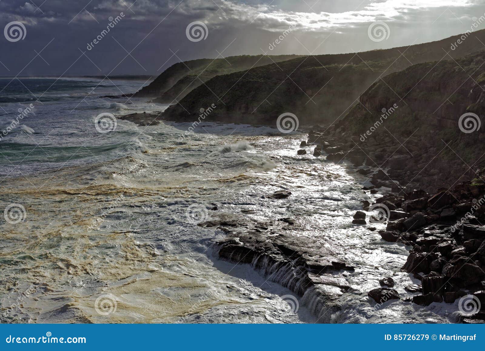 foamy sea by wild waves at rocky coast landscape
