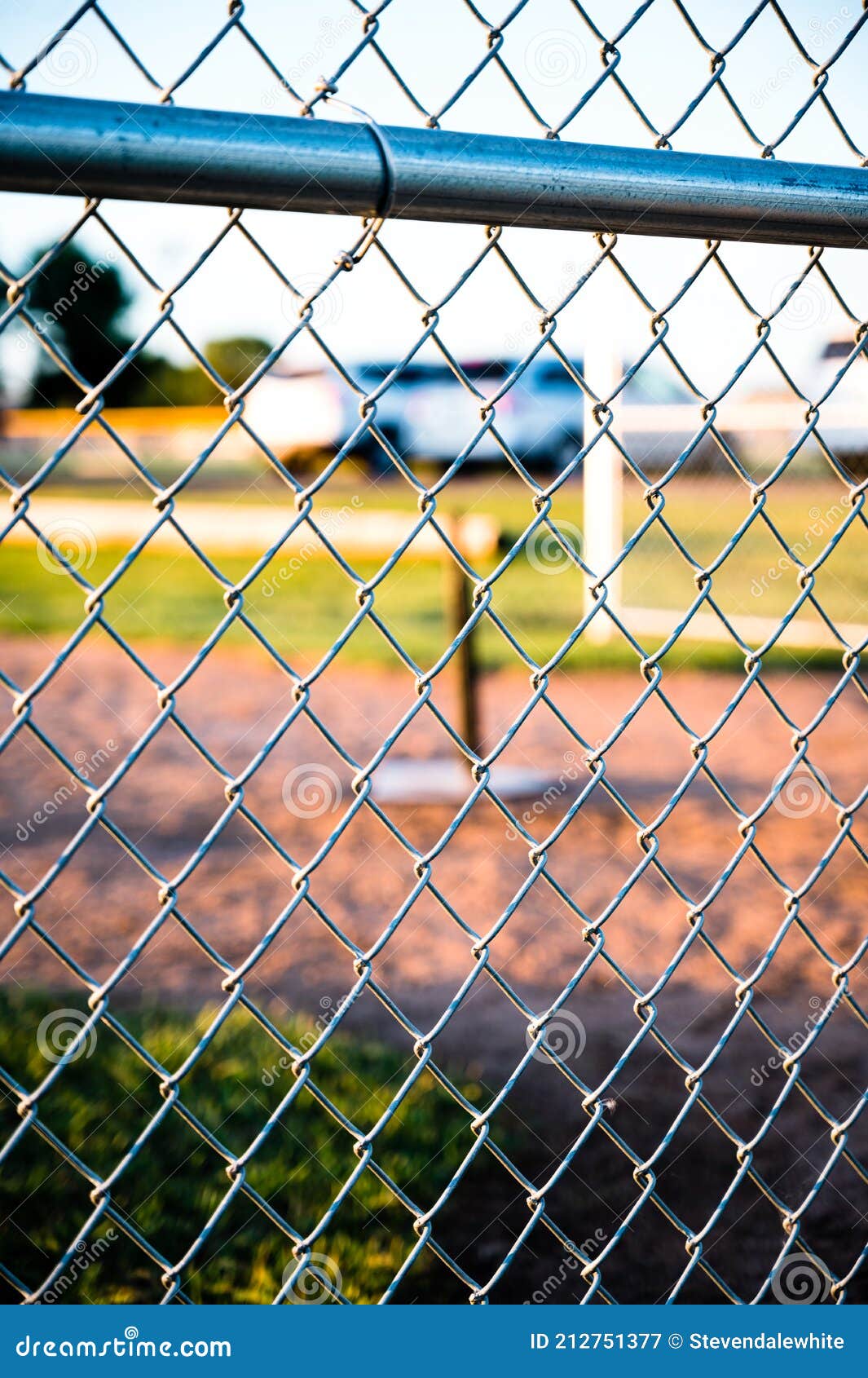 focus on chain link fence with t-ball background