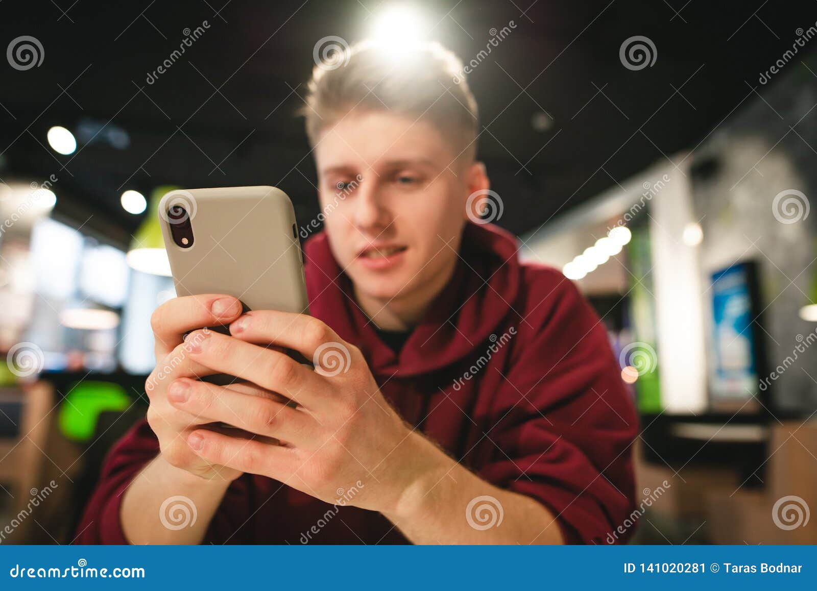 Focus on Smartphone, Positive Guy Uses the Internet on a Smartphone ...