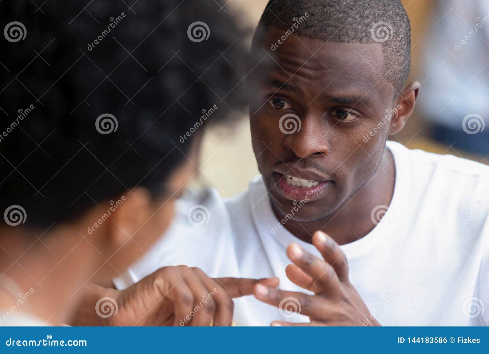 focused african man having serious talk with woman at meeting