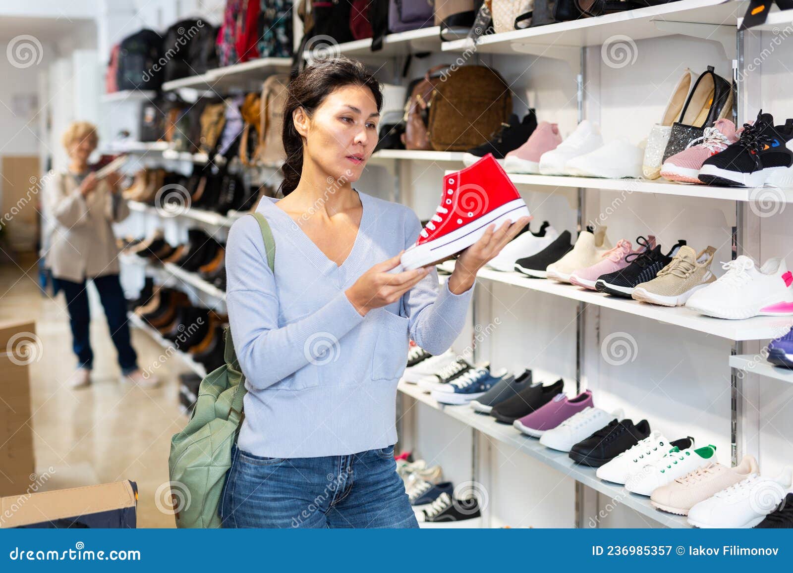 Focused Asian Woman Chooses Casual Sneakers Converse Stock Image ...