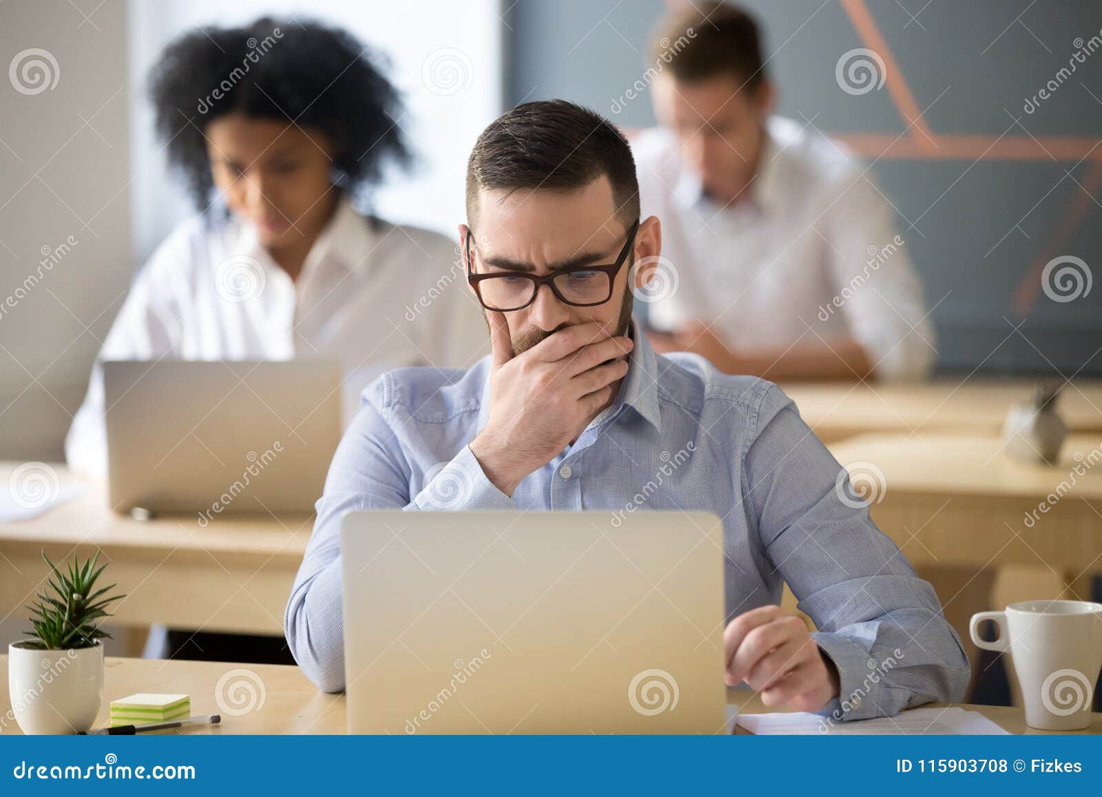 Focused Businessman Solving Online Problem Working on Laptop in Stock