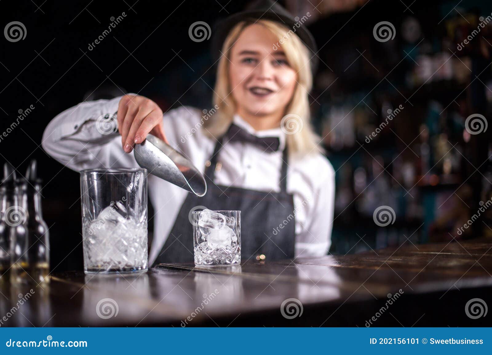 Pretty Woman Bartender Places the Finishing Touches on a Drink while ...