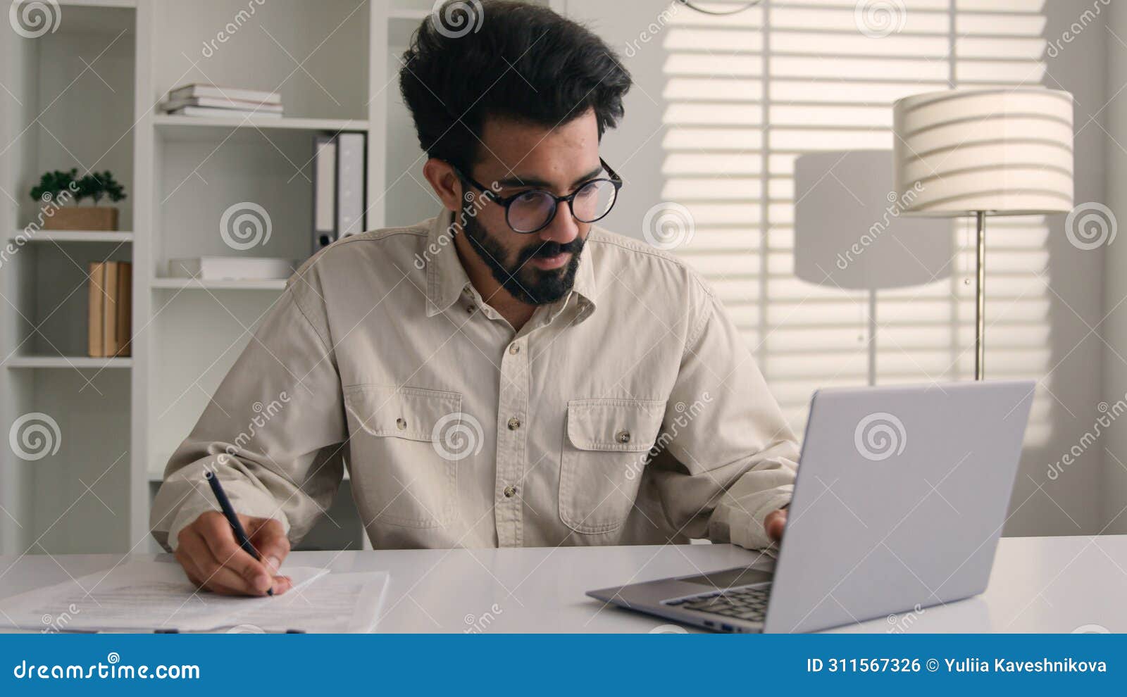 focused man arabian indian ethnic businessman male employee manager writing notes business tasks data paperwork signing