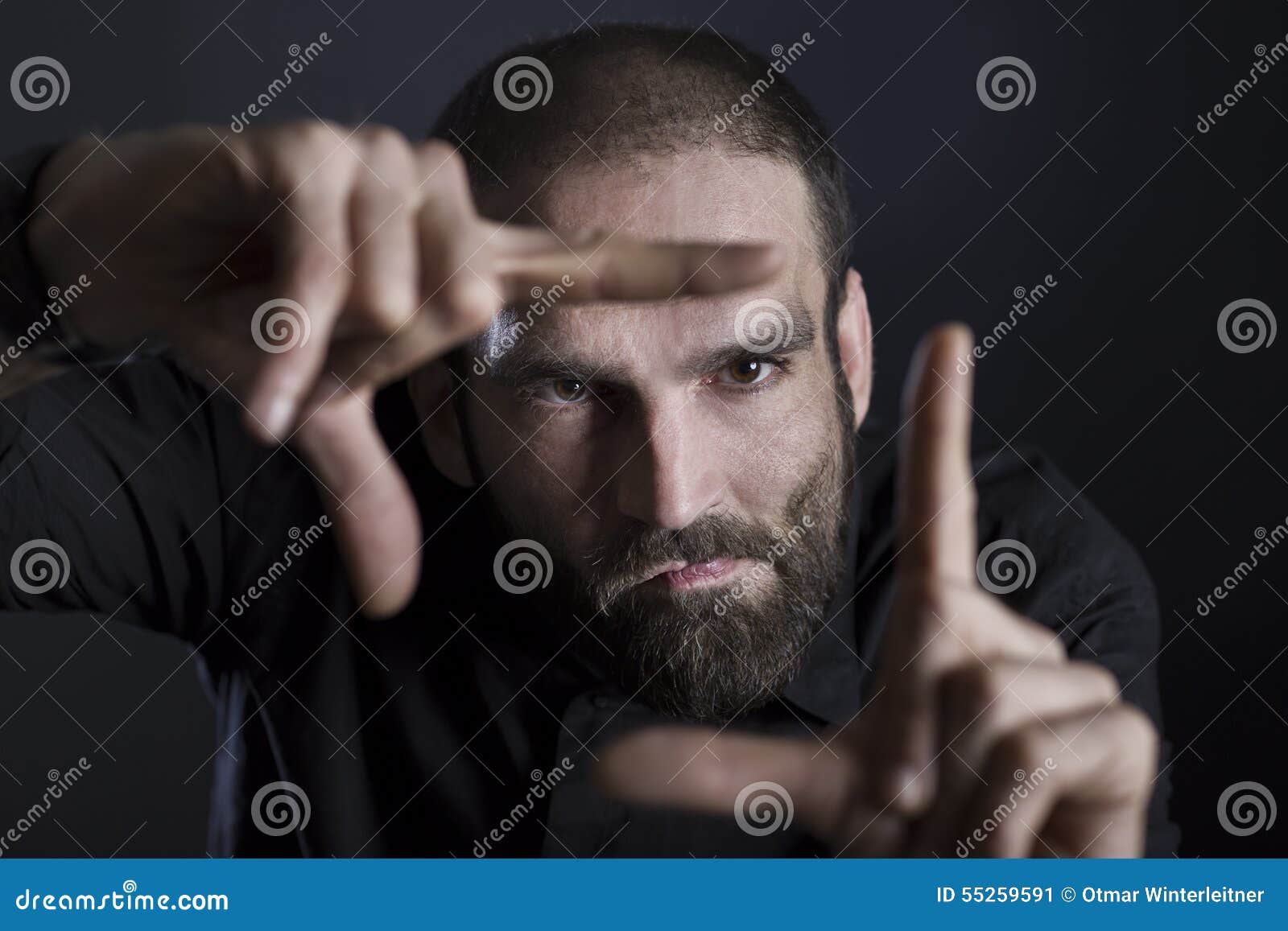 focused man building frame with fingers.