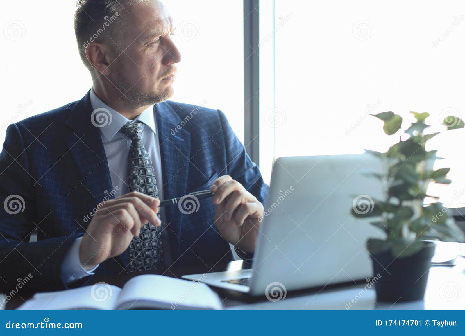 focused mature businessman deep in thought while sitting at a table in modern office