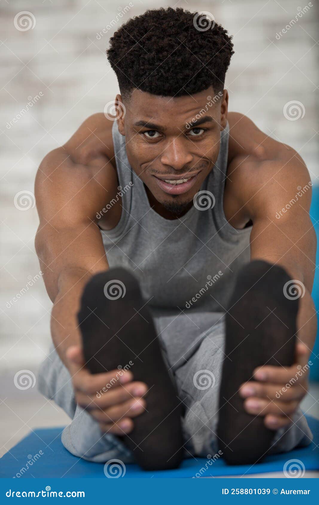 focused mid adult man stretching leg while practicing yoga
