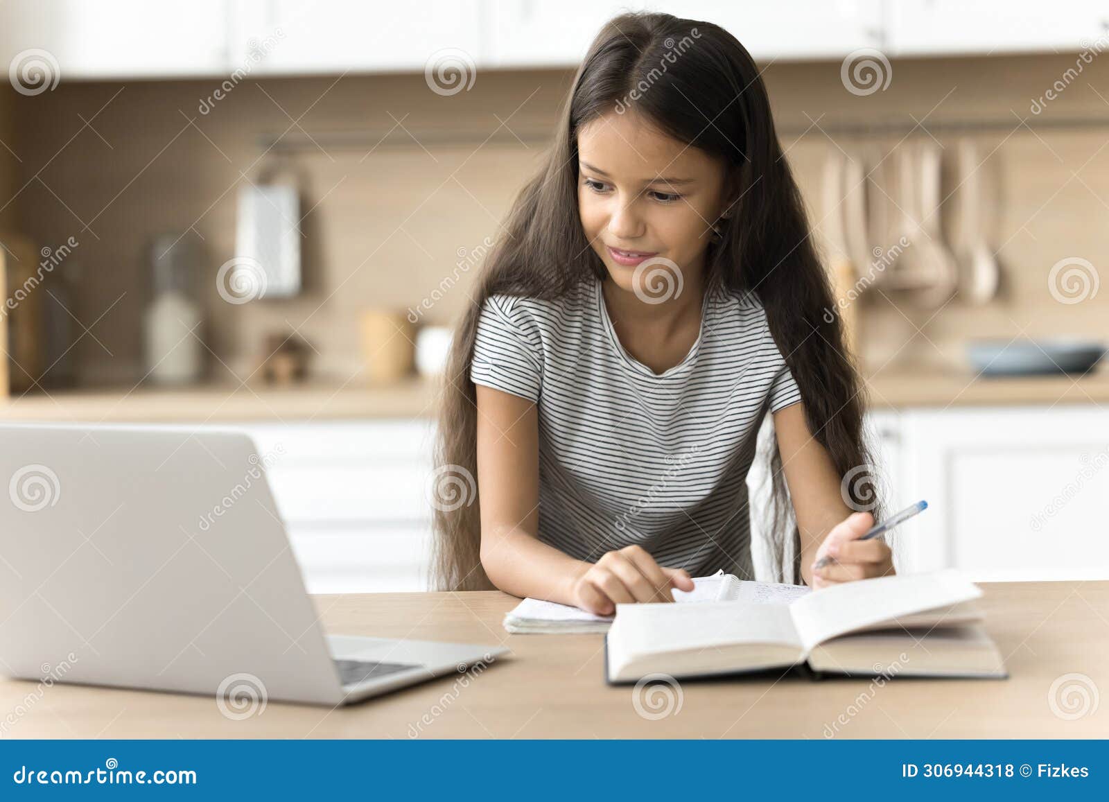 focused positive schoolkid studying at home, watching online lesson