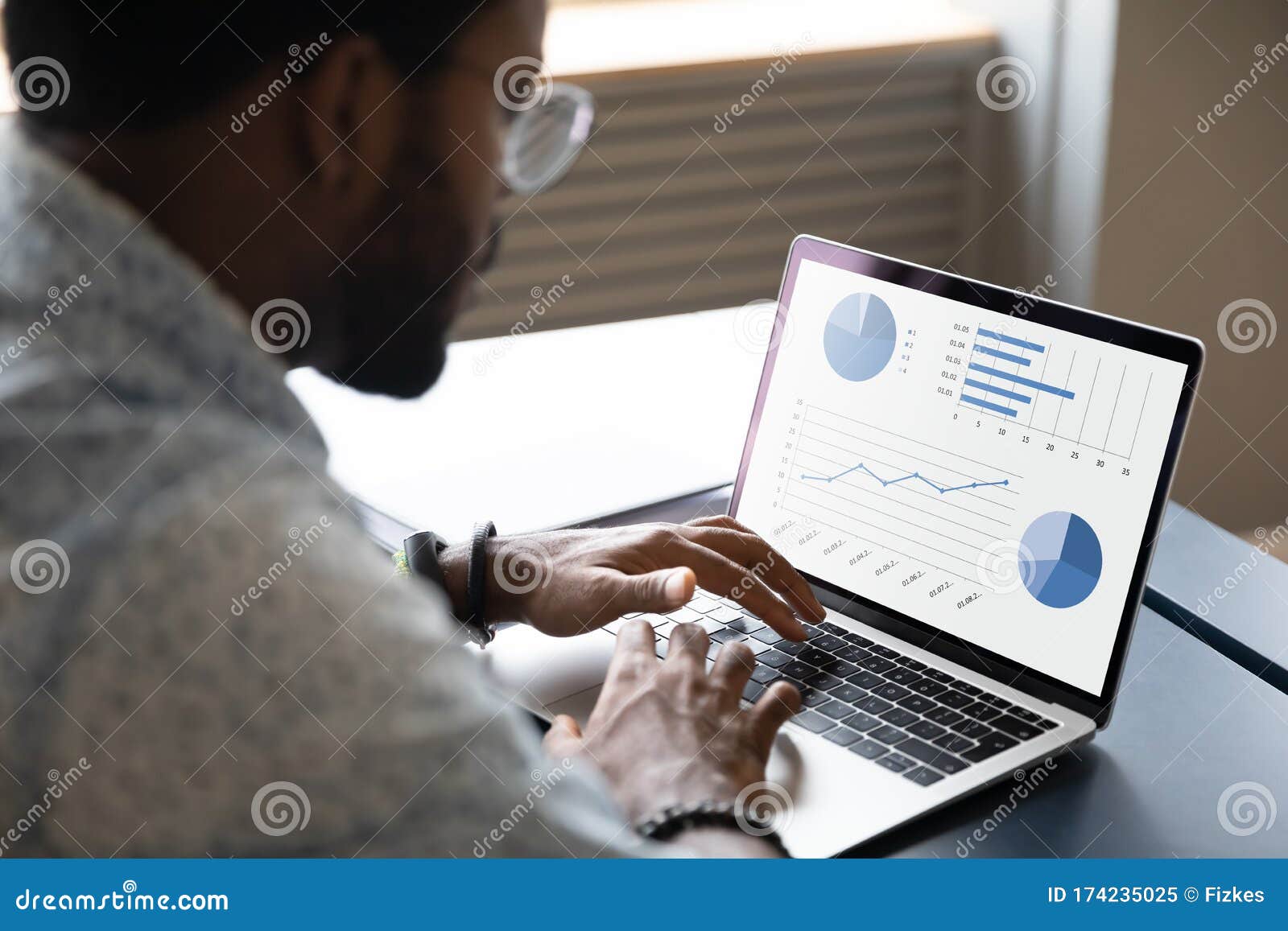 focused young african ethnicity male marketing specialist analyzing graphs.