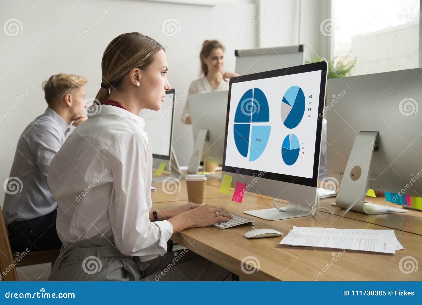 focused woman working with statistics charts using computer in o