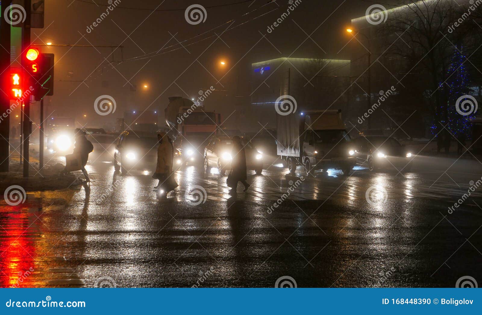 foggy night crossing with pedestrains, wet asphalt road, street and car lights