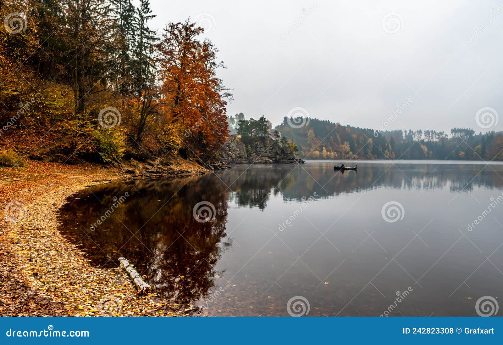 Foggy Landscape With Fishermans Boat On Calm Lake And Autumnal Forest