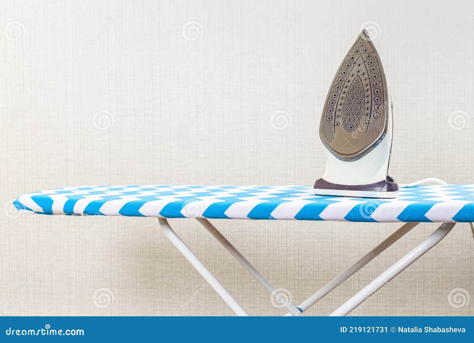 Folded Ironed Men`s Shirts Lie Next To the Iron on the Ironing Board