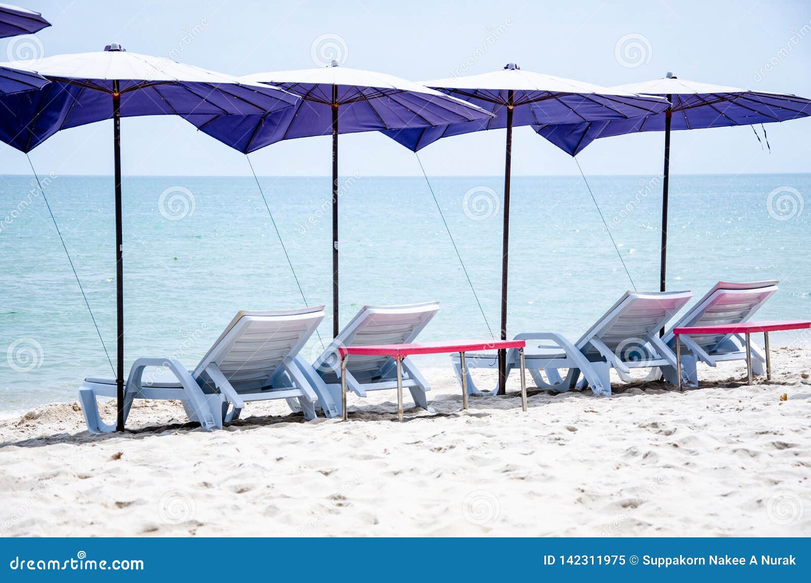 Folding Chairs with Umbrellas are Located on the Beach for Sleeping and