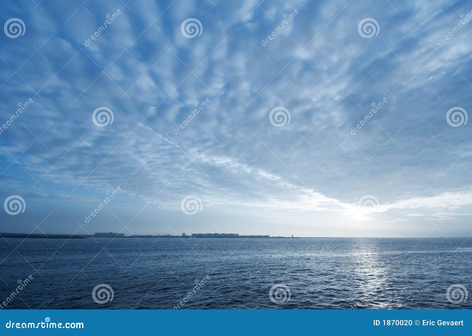 Fondo azul de la puesta del sol. Nubes de la puesta del sol y fondo azules del agua