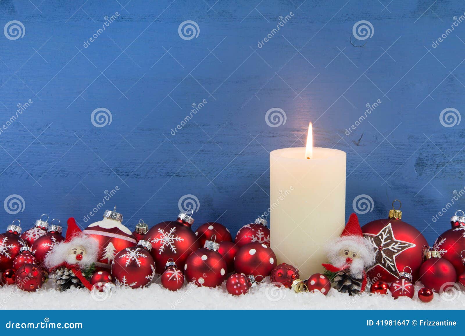 Fondo de madera azul de la Navidad con una vela blanca y un bal rojo. Fondo de madera azul de la Navidad con una vela ardiente blanca y bolas rojas