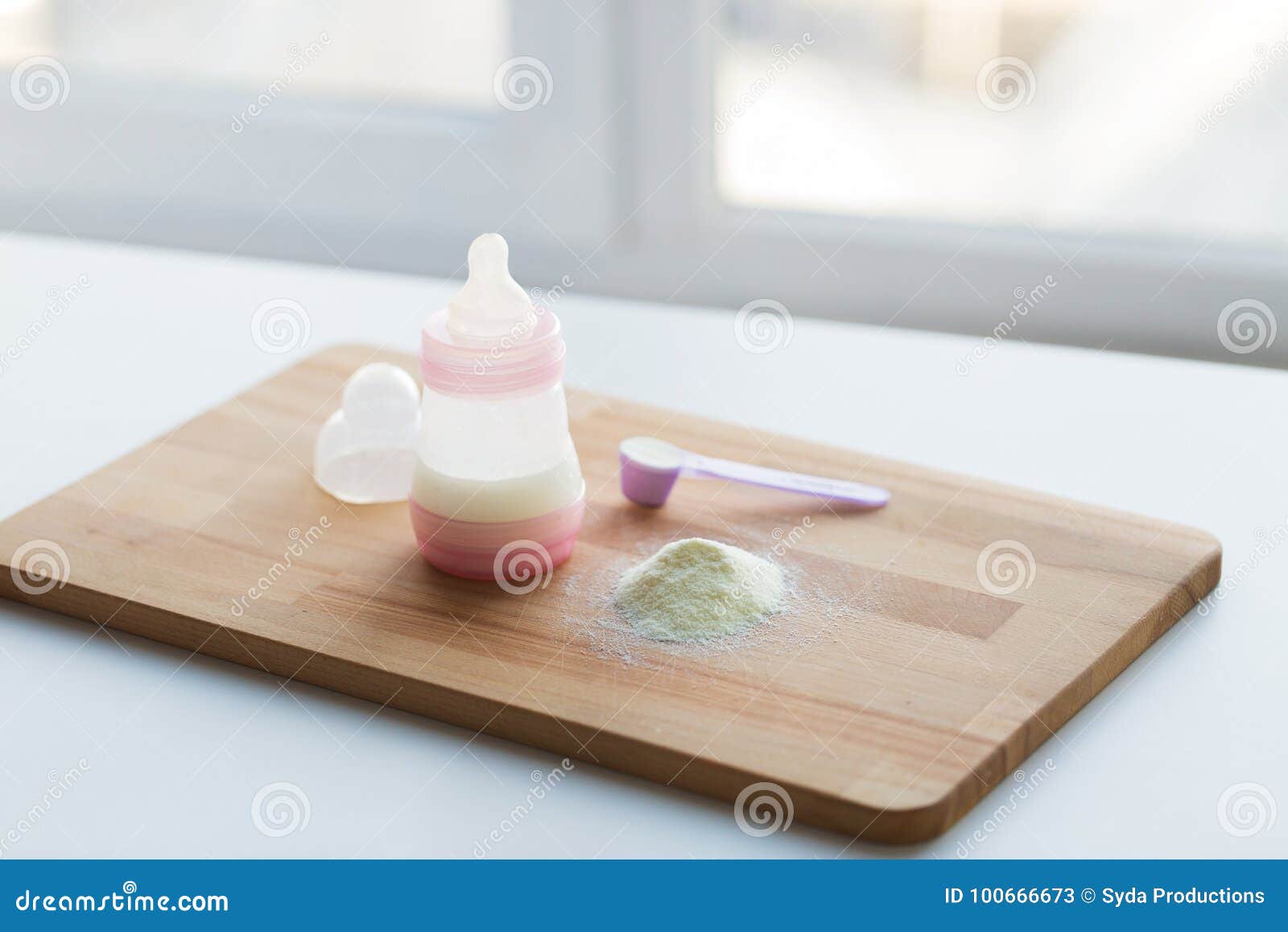 infant formula, baby bottle and scoop on board