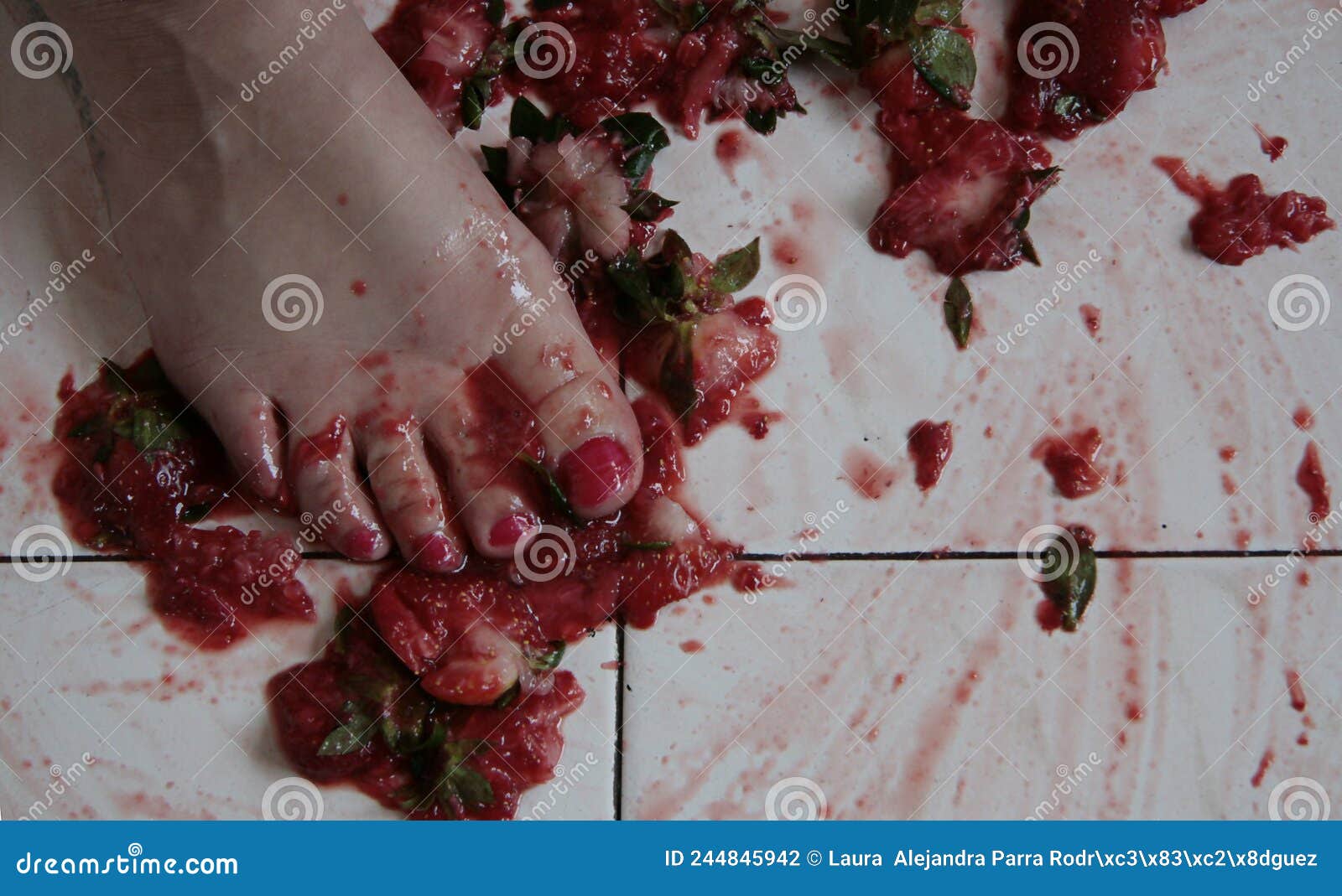 foot mashed strawberries on a white floor fresas machacadas con el pie en un piso blanco