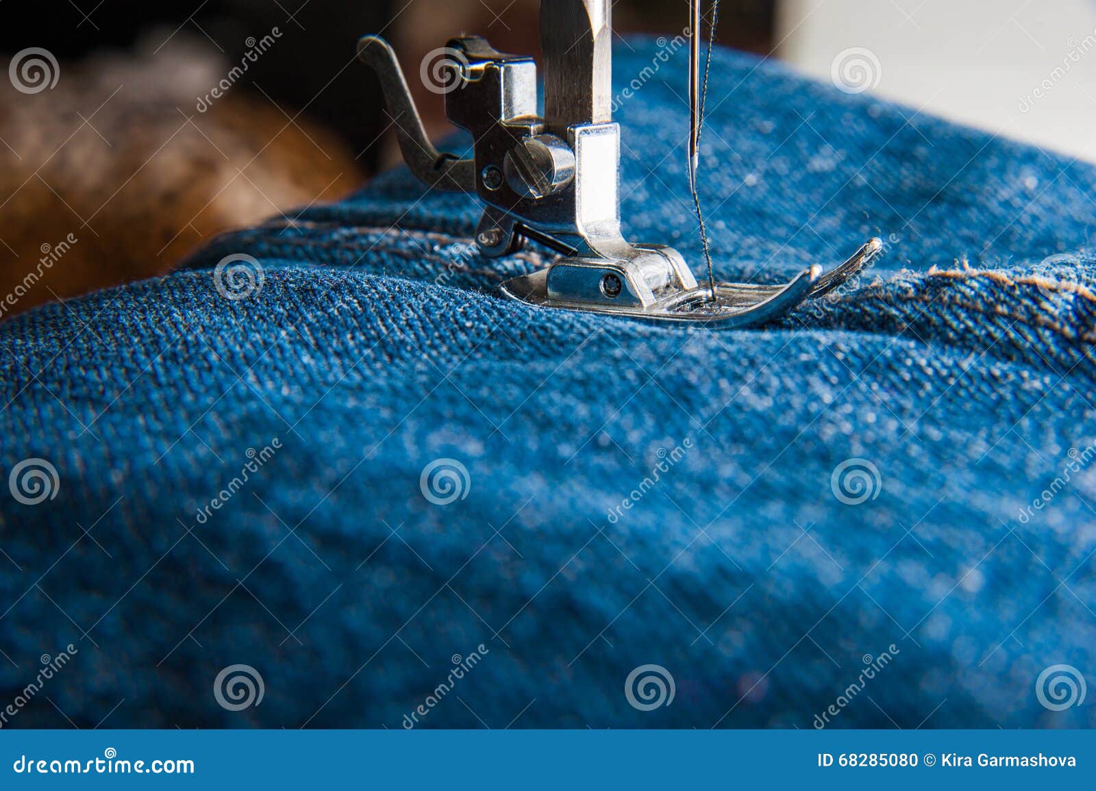 A needle and thread sew up a hole in a denim. Work of a seamstress or  tailor with a needle Stock Photo - Alamy