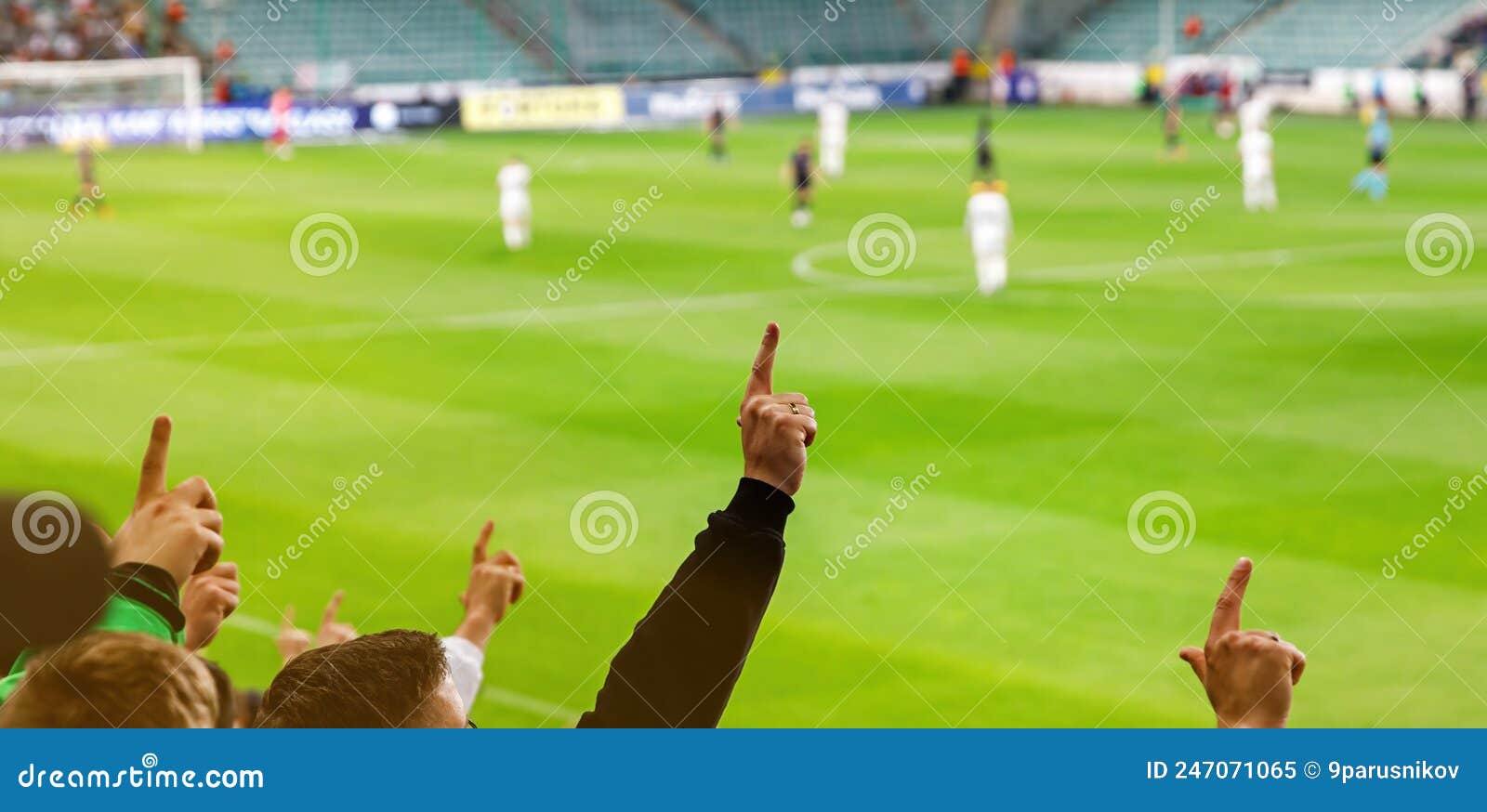 football fans with raised hands at the stadium during their favorite team match.