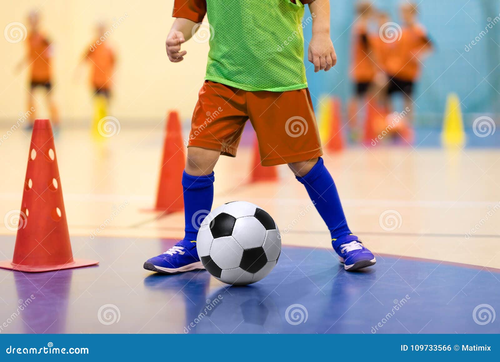 Footballer Dribbling Ball On Training Between Orange Cones Young