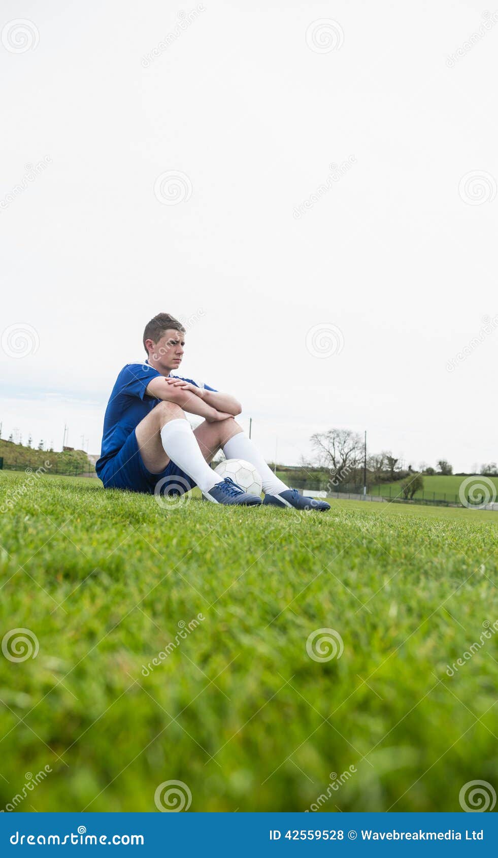 Football Player in Blue Taking a Break on the Pitch Stock Photo Image