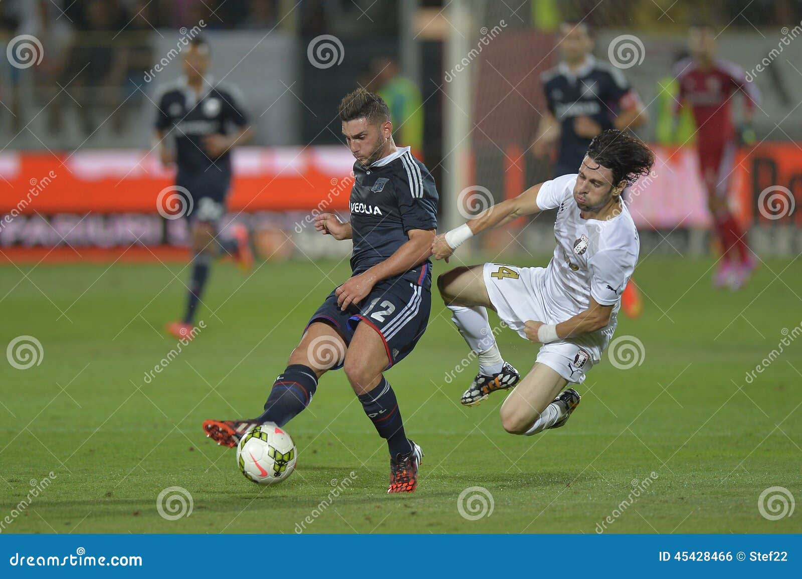 Free Stock Photo of Two footballers are fighting for the ball on the  football field