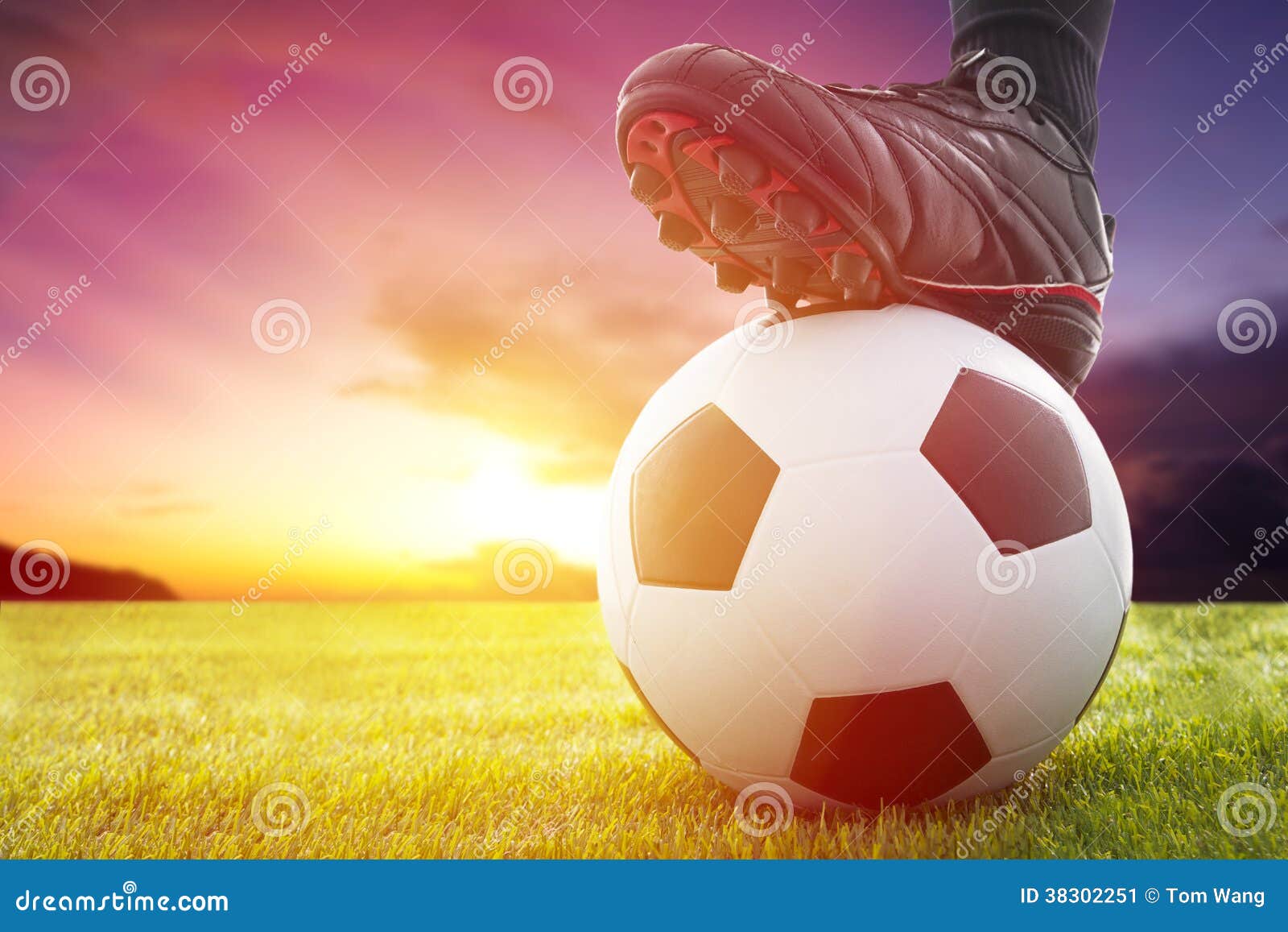 football or soccer ball at the kickoff of a game with sunset