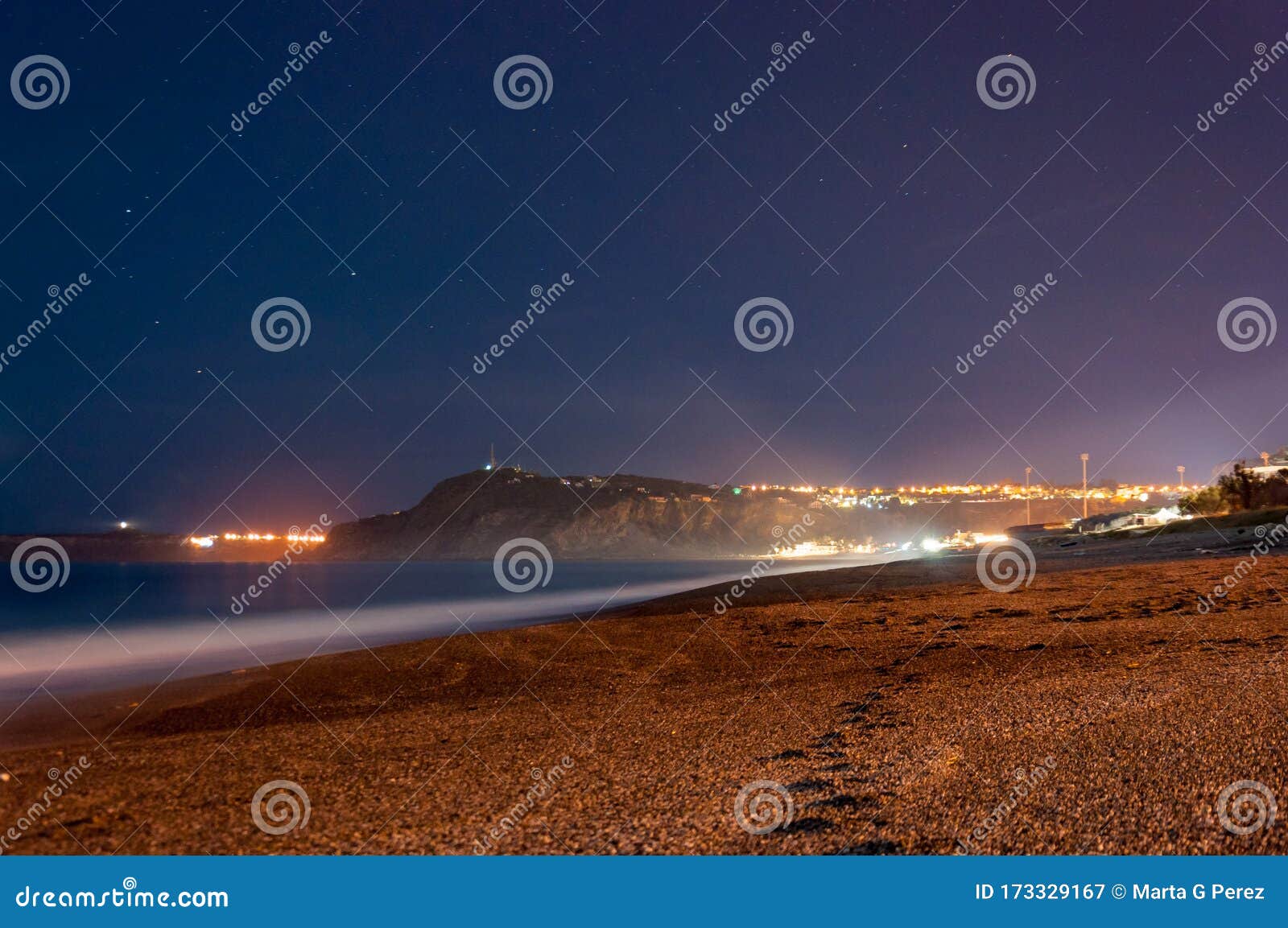 footprints leading to the little foggy tono`s bay or baia del tono. silk effect and some stars in the background. sicily, italy
