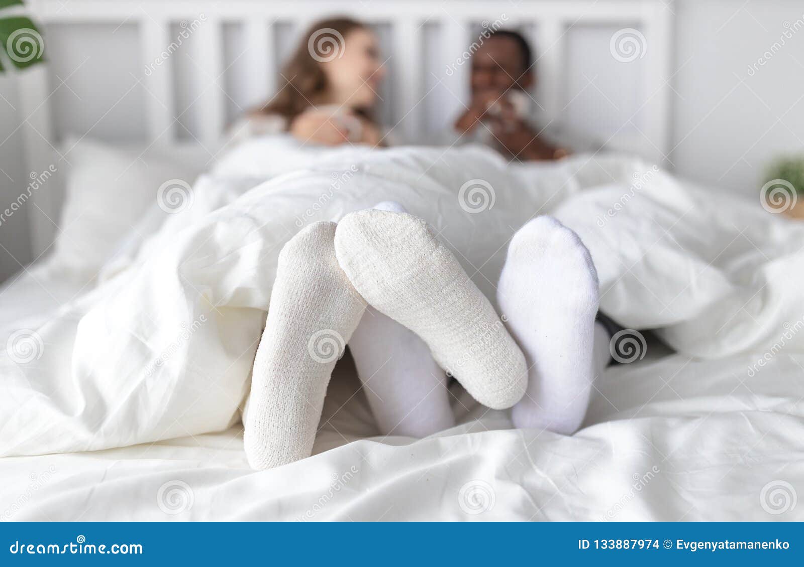 foots of happy couple in love on winter morning in bed