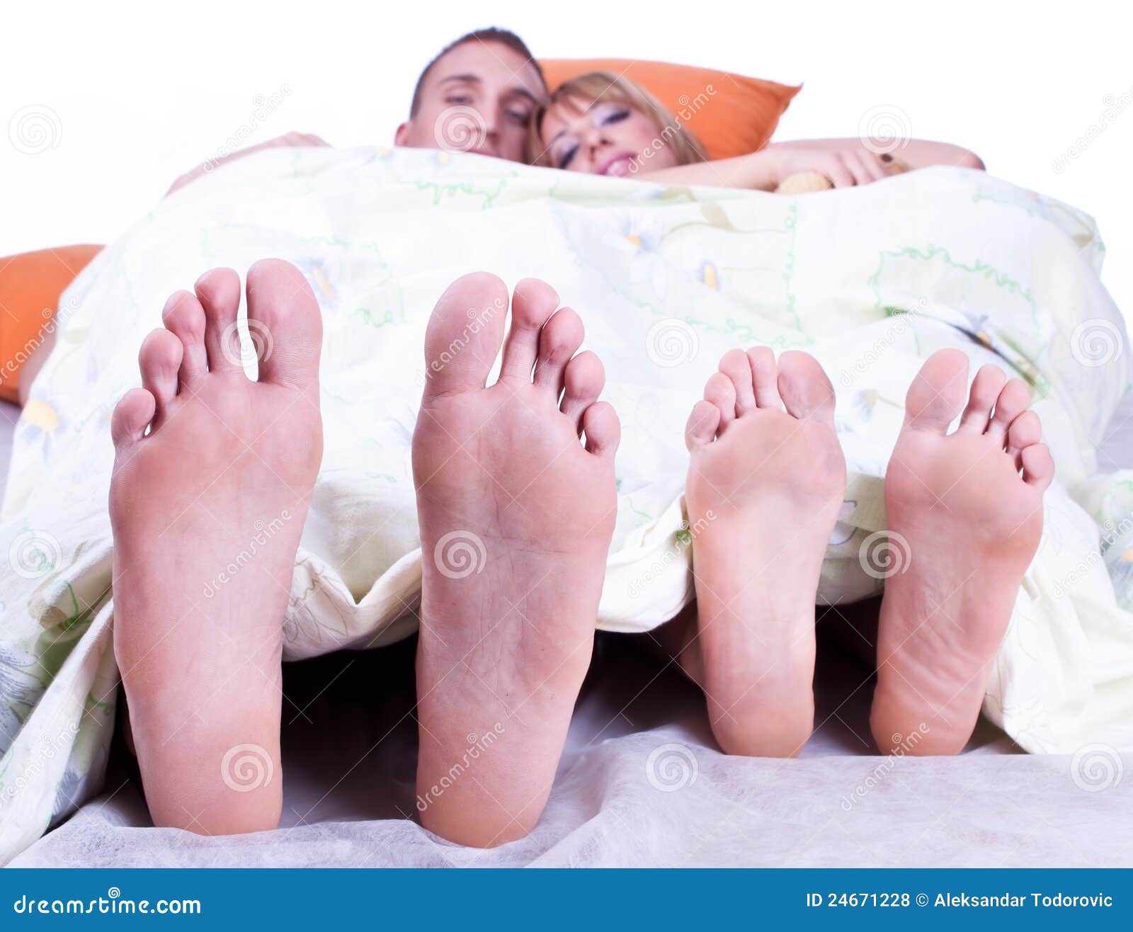 foots of young couple lying in bed