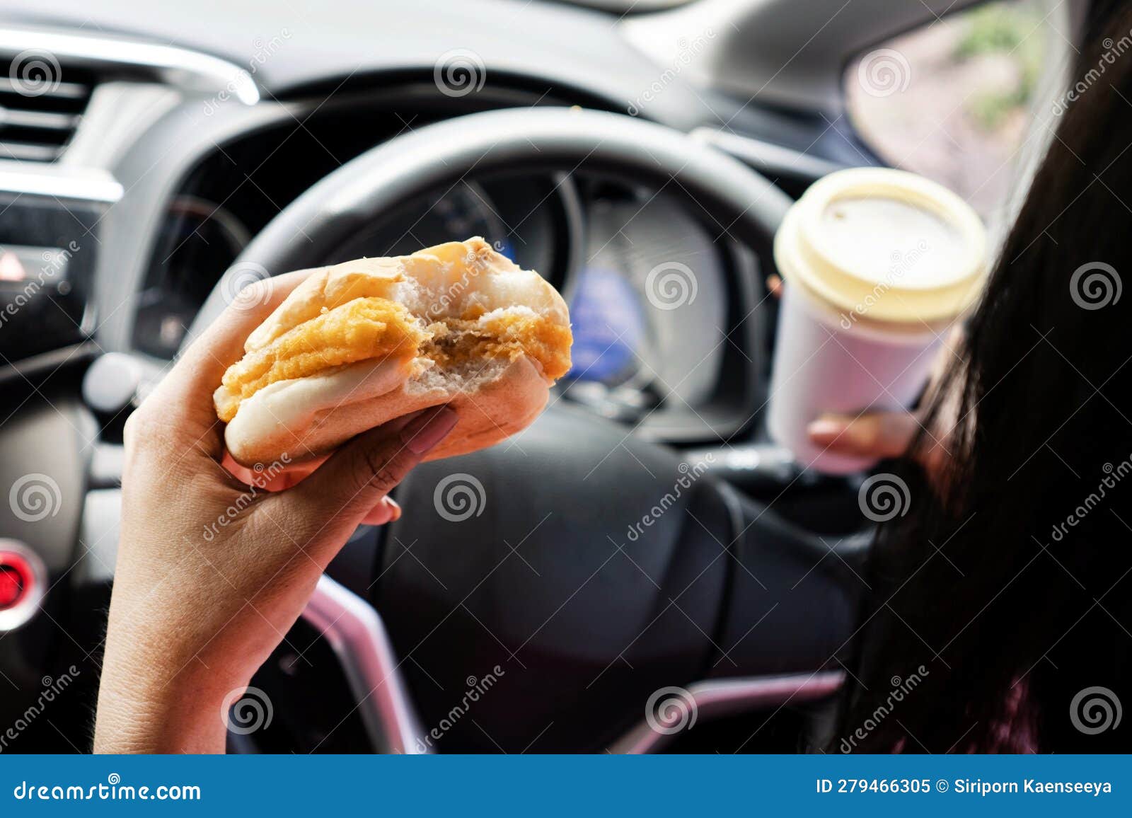 forbidden and perilous with close-up of woman's hand, holding burger and coffee, while driving