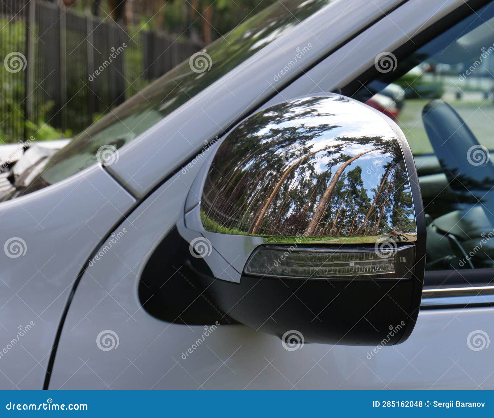 Chrome Protection Panel on a Car Mirror with Reflection of Trees Stock