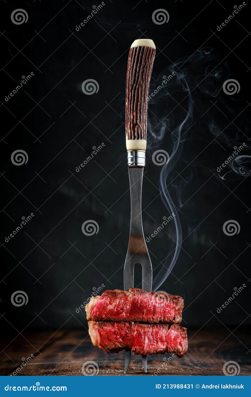 Fork with Sliced and Steaming Grilled Beef Fillet Steak on a Wooden
