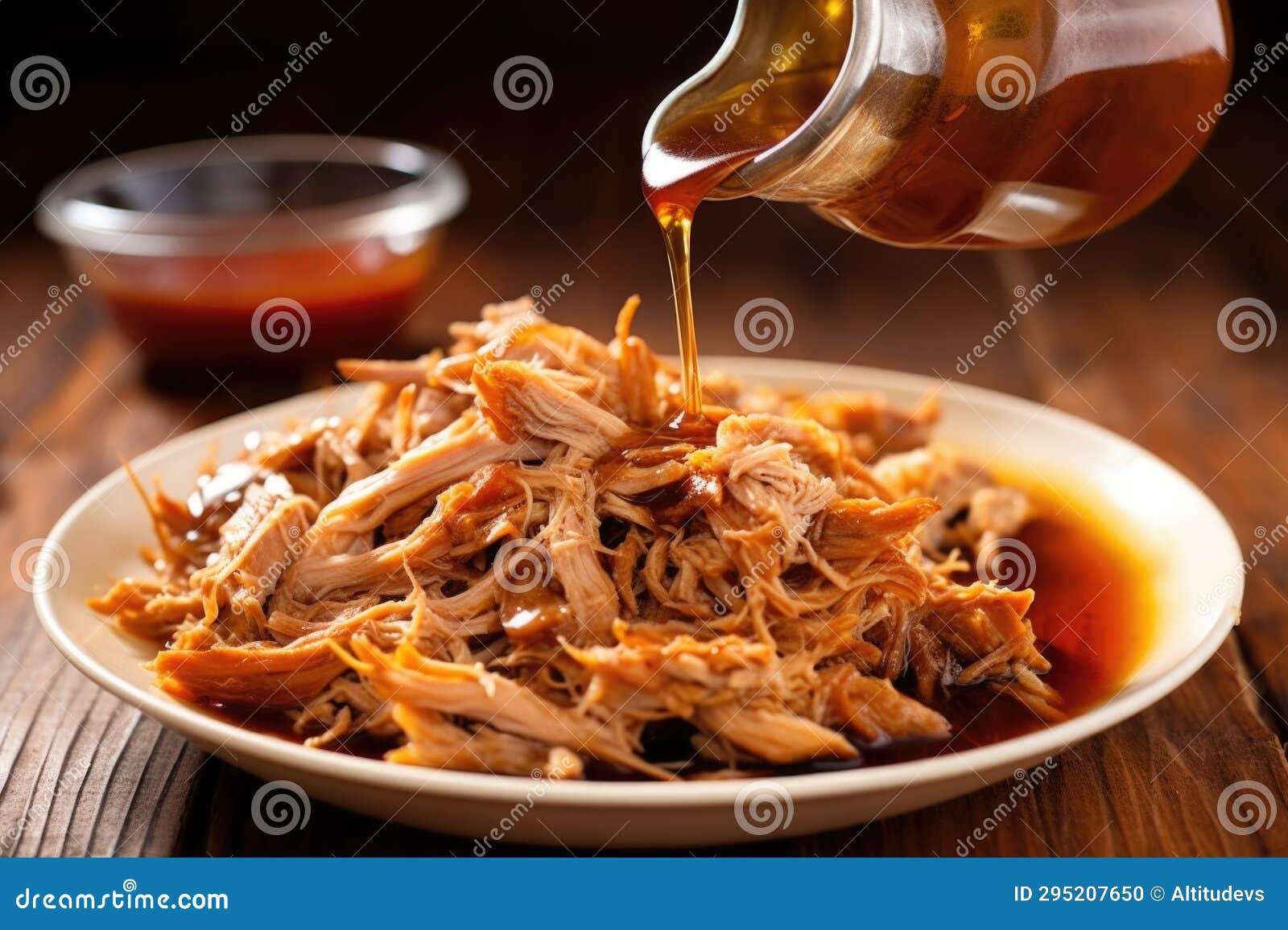 Forkful of Pulled Pork Drenched in Vinegar Sauce Over a Plate Stock