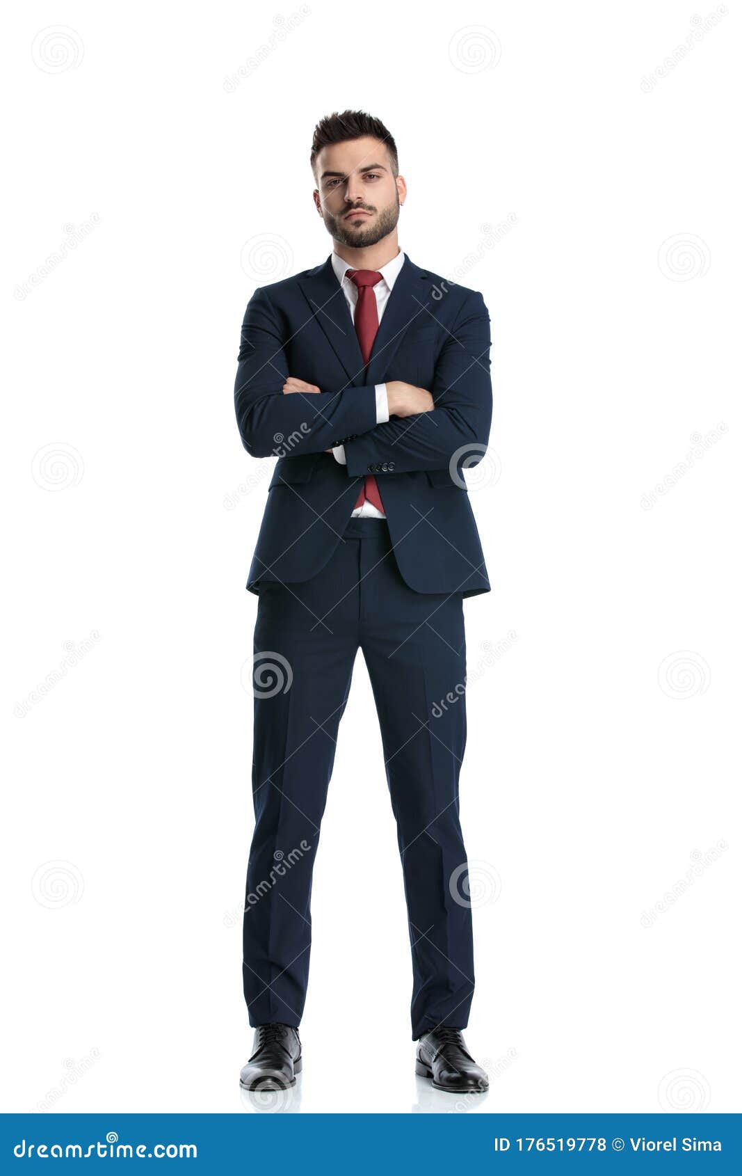 Young fashion male model in suit holding button and posing in studio. |  CanStock