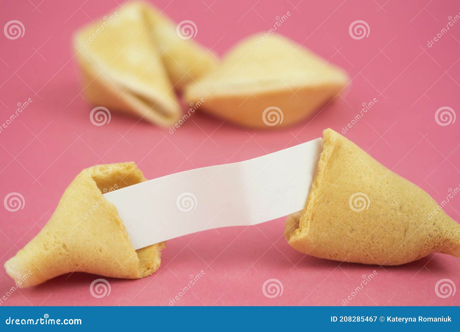 fortune cookie on a crimson background.close-up of foreboding broken cookies with white paper with copy space on a dark pink