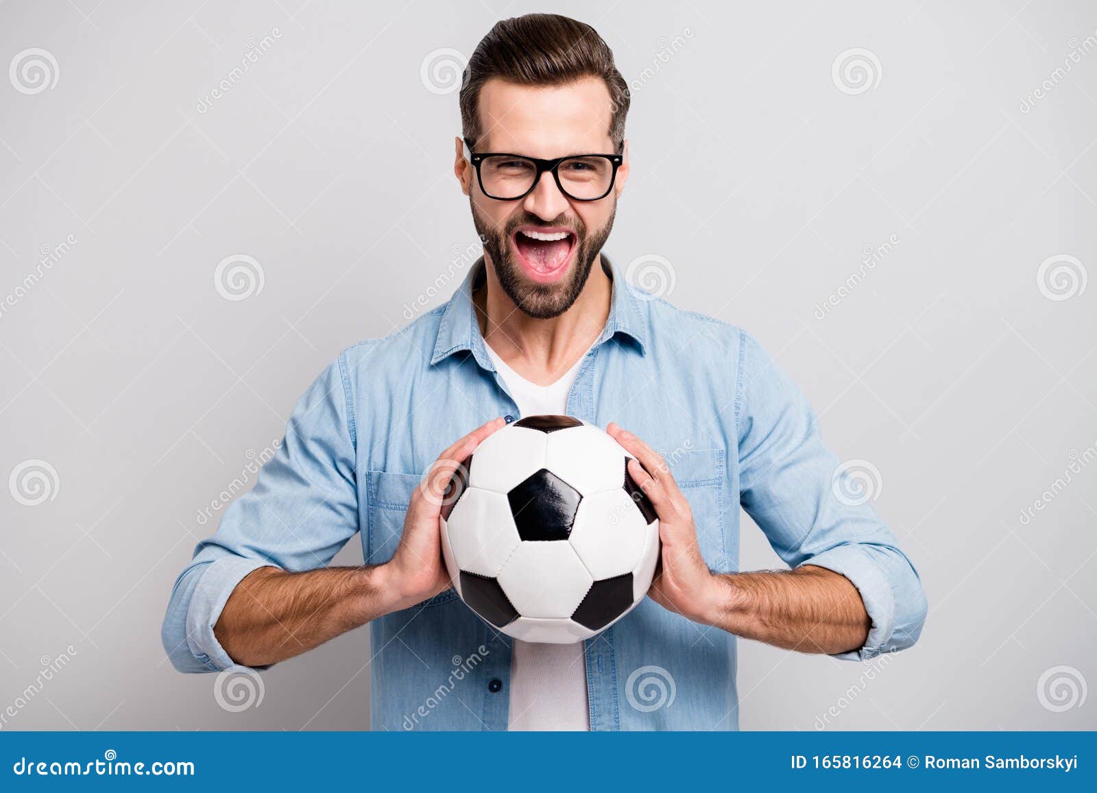 Um garoto segurando a velha bola de futebol antes de começar um jogo de  futebol