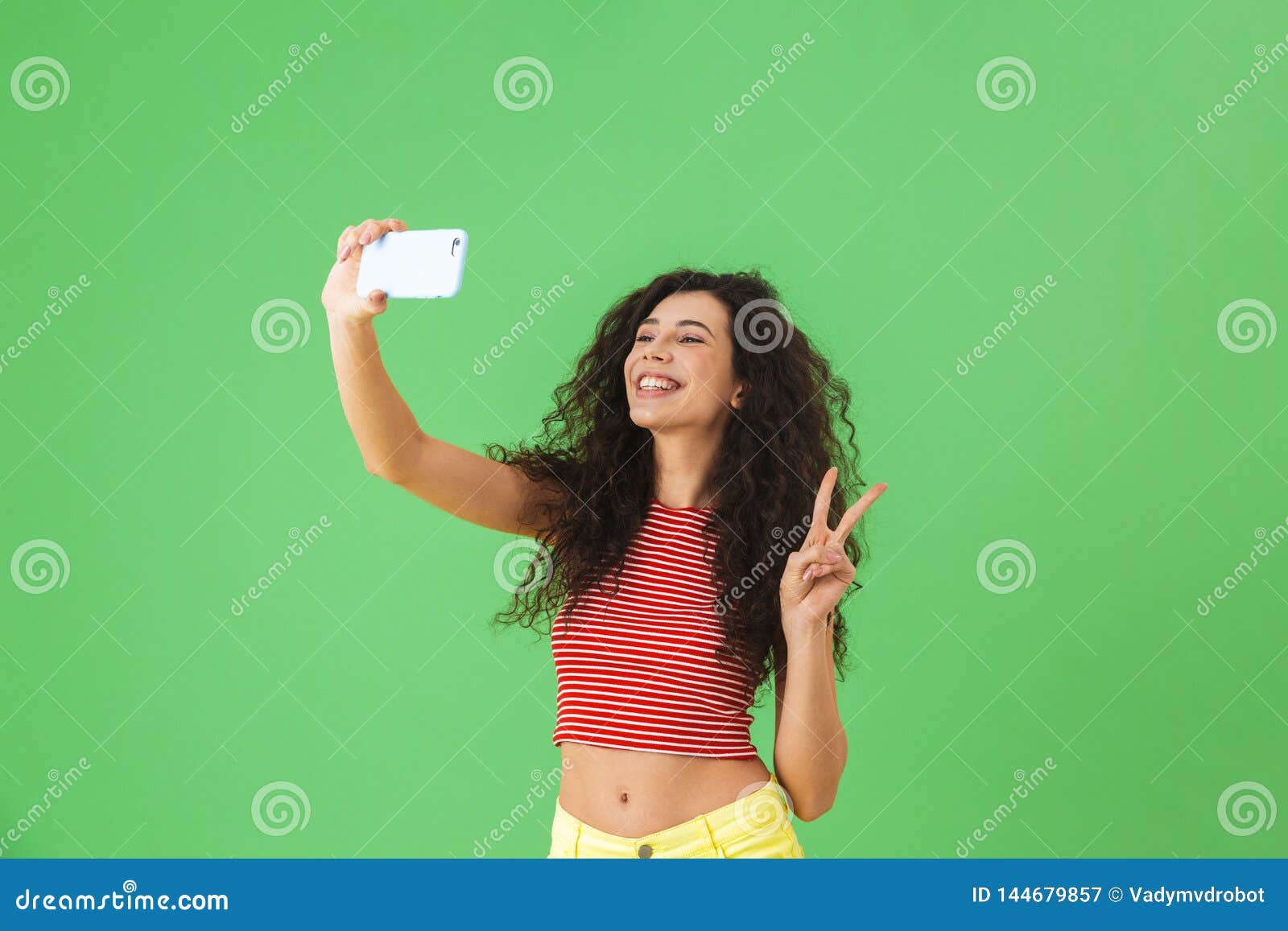Foto De La Mujer Contenta Que Sonríe Y Que Usa El Teléfono Celular Para El  Selfie Aislado Sobre Fondo Verde Imagen de archivo - Imagen de elegante,  interior: 144679857