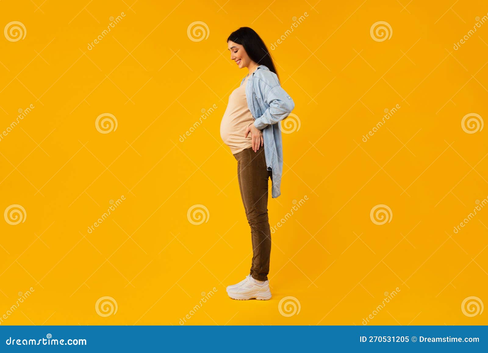 Foto De Perfil De Una Mujer Embarazada Posando Sobre Un Fondo Amarillo  Mirando El Vientre Y Sonriendo Disfrutando Del Tiempo De Es Imagen de  archivo - Imagen de estudio, amor: 270531205