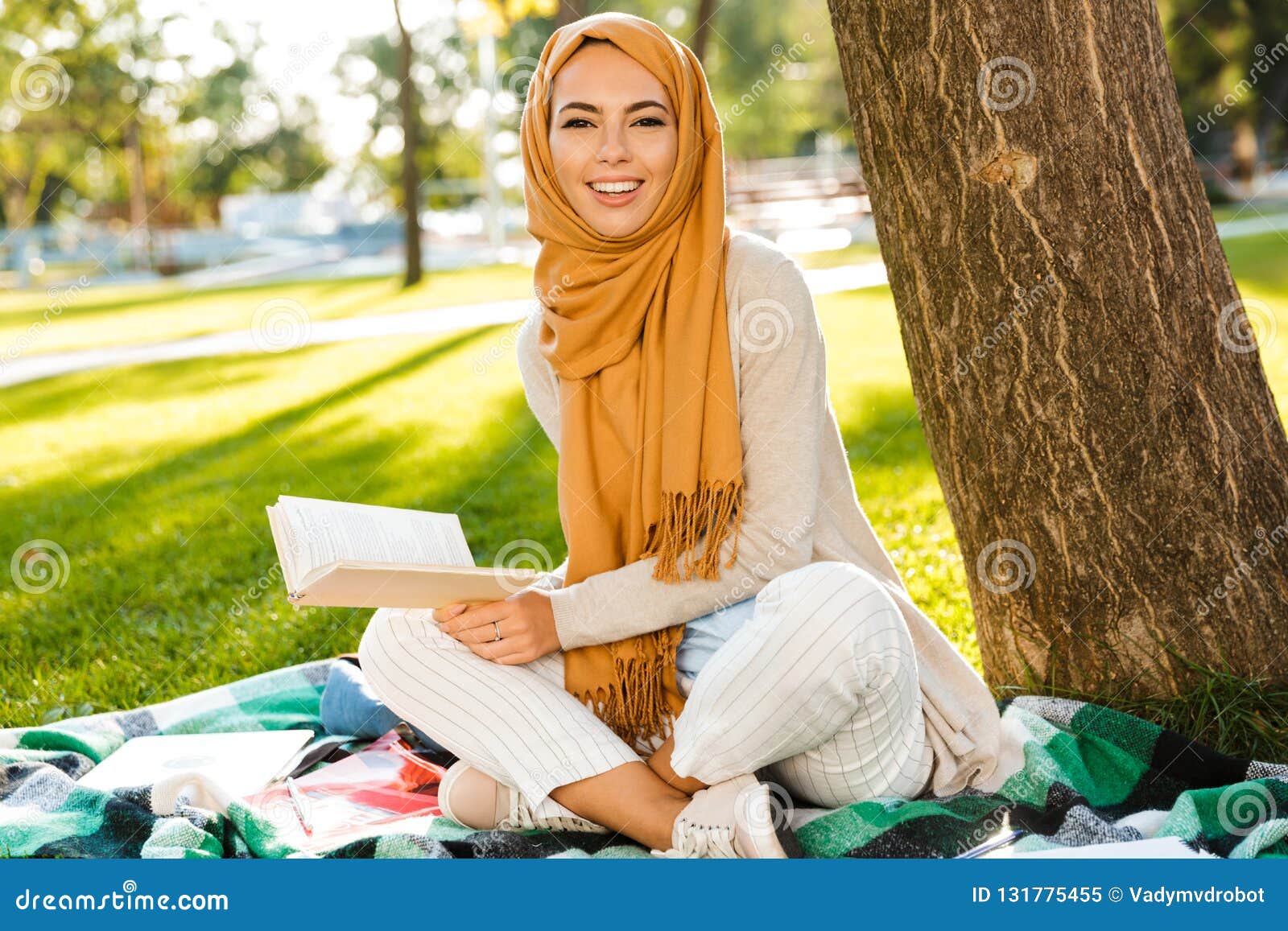 Foto Del Pañuelo Que Lleva De Mujer árabe Hermosa Que Se Sienta En La Manta En Parque Verde Imagen de archivo - Imagen de sentada, musulmanes: 131775455